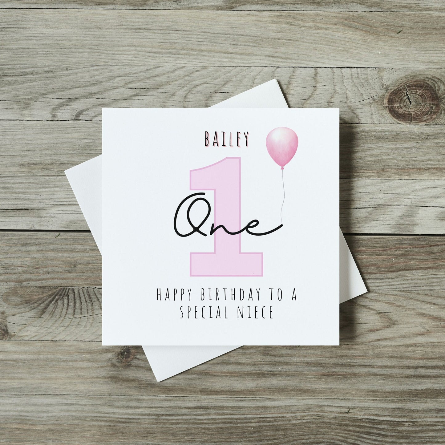 front of childrens birthday card with large number one in pink and personalised name